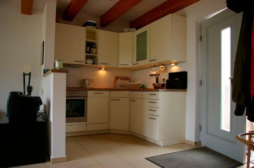 eine kleine Küche mit weißen Schränken und einem Fenster in der Unterkunft Ferienhaus in Heiligendamm mit Sauna & Kamin - [#23967] in Heiligendamm