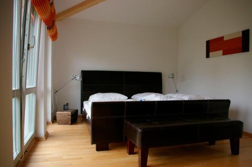 ein Schlafzimmer mit einem Bett und einem schwarzen Ledersessel in der Unterkunft Ferienhaus in Heiligendamm mit Sauna & Kamin - [#23967] in Heiligendamm