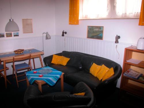 a living room with a black couch and a table at Silva Mare, UG 2 in Kellenhusen