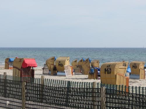 a beach with chairs and umbrellas and the ocean at Rosa Canina W2 in Kellenhusen