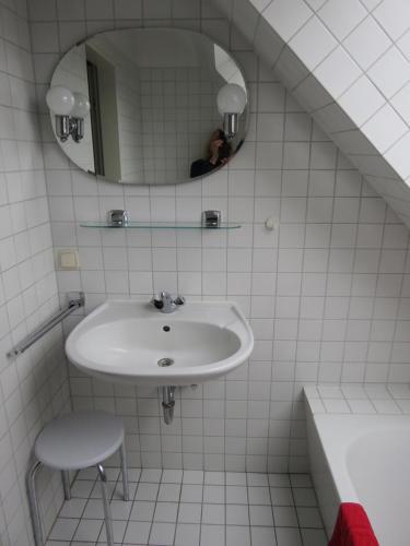 a white bathroom with a sink and a mirror at Rosa Canina W11 in Kellenhusen