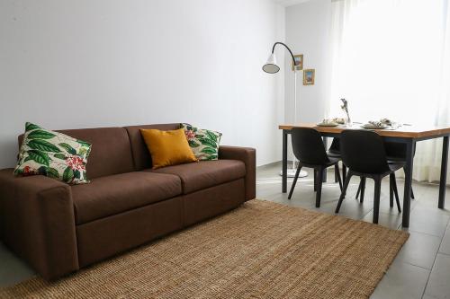 sala de estar con sofá marrón y mesa en Domus Silvana Apartments, en Rávena