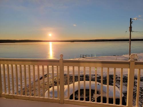 a view of a body of water with the sun setting at Trailsman Lodge in Baddeck