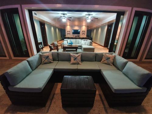 a living room with a large couch and a table at Fishers Landing Boutique Hotel in Roatan