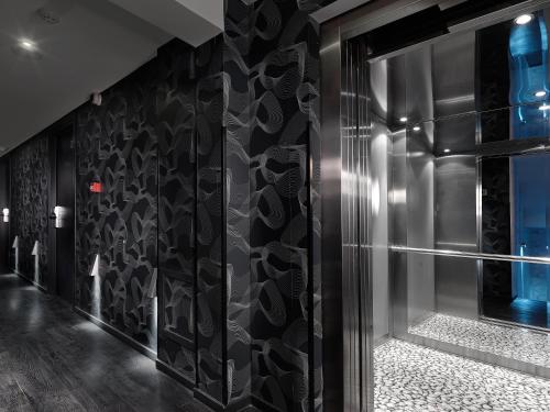 Zimmer mit einer Wand mit schwarzen und weißen Fliesen in der Unterkunft Airotel Patras Smart Hotel in Patras