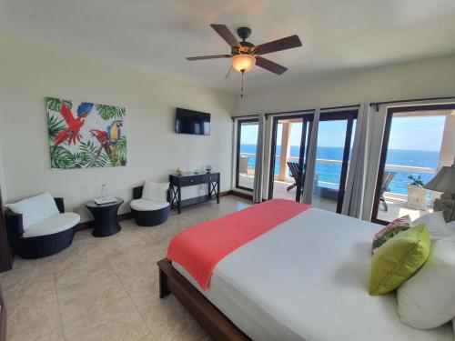a bedroom with a bed and a view of the ocean at Fishers Landing Boutique Hotel in Roatán