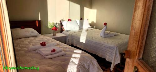 a bedroom with two beds with swans on them at Tikawasi Homestay Comunidad Pueblo Isla Amantani José Luis in Amantani