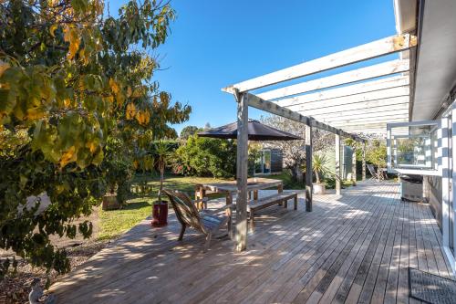 a wooden deck with a bench and an umbrella at Driftwood Beach House with Spa Pool - Absolute Beachfront! in Blackpool