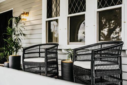 two wicker chairs on the front porch of a house at Gilbert by Whiskey June in Maryborough