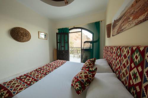 a bedroom with a bed and a window at The Bedouin Moon in Dahab