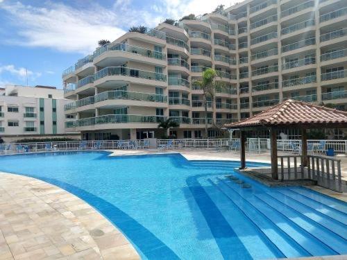 a large apartment building with a large swimming pool at Villas del Sol praia da macumba in Rio de Janeiro