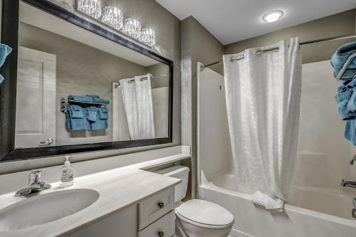a bathroom with a sink and a toilet and a mirror at Newly Renovated Ocean Front Condo, Modern Decor, Central MB, 20th floor in Myrtle Beach