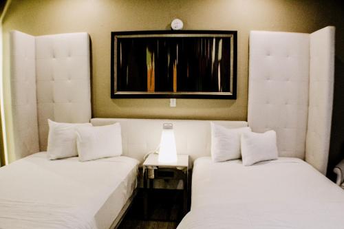 two beds sitting next to each other in a room at Devonshire Inn Motel in Rosamond