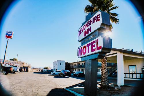a hotel sign in front of a motel at Devonshire Inn Motel in Rosamond