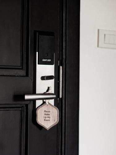 a door with a lock on it with a tag on it at Burirattana Hotel-An Adults Only Hotel in Chiang Mai