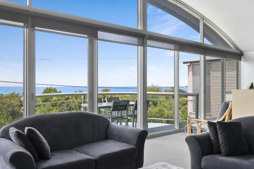 a living room with a couch and a view of the ocean at Magnum in Lorne