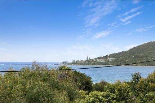 a view of a body of water with a hill at Magnum in Lorne