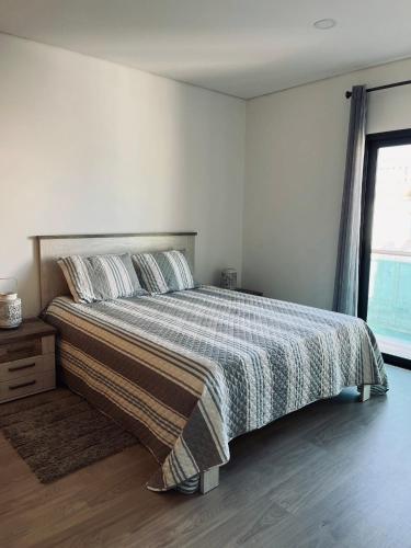 a bedroom with a bed with a checkered blanket at Casa Marta e Casa Francisco in Olhão