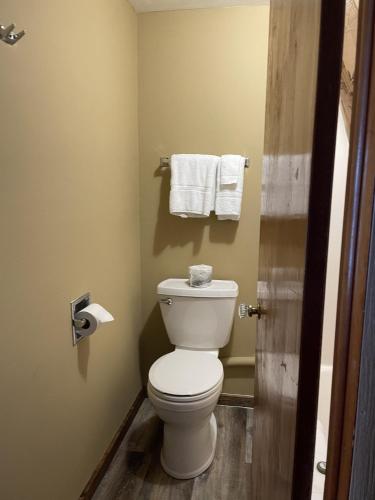 a bathroom with a white toilet and towels at adoba® Dreamland in Gulliver
