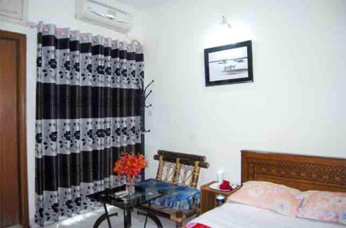 a bedroom with a bed and a table at Marry House in Dhaka