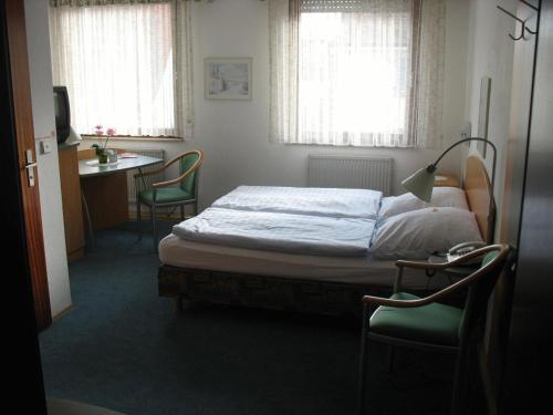 Schlafzimmer mit einem Bett, einem Tisch und Stühlen in der Unterkunft Hotel Urbanus in Heilbronn