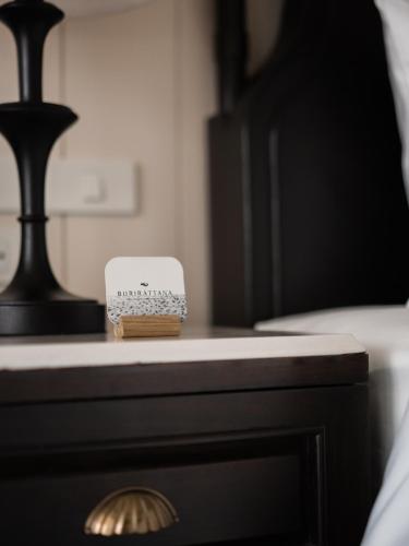 a nightstand with a phone on top of it at Burirattana Hotel-An Adults Only Hotel in Chiang Mai