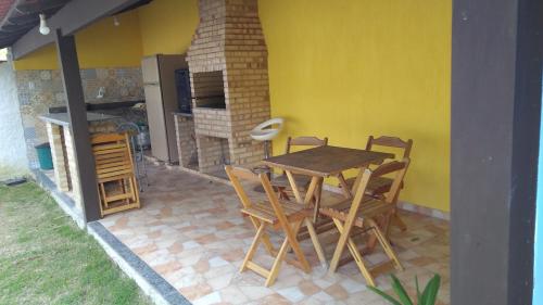 einen Tisch und Stühle auf einer Terrasse mit einer Küche in der Unterkunft Guest House LuLi in Búzios