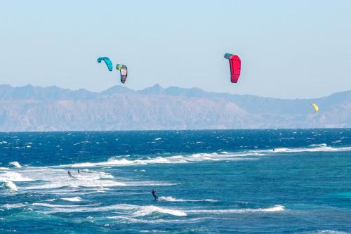 three people are kite surfing in the ocean at The Bedouin Moon in Dahab
