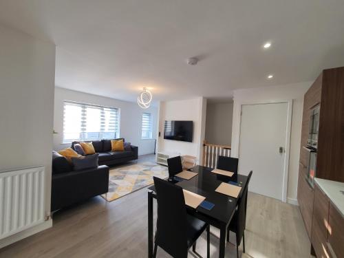 een woonkamer met een tafel en een bank bij Lovely home close to City Center & Rail Station in Chesterfield