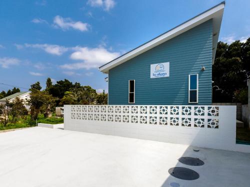 a blue building with a white fence in front of it at la ohana～瀬底島～（2022年OPEN） in Okinawa City