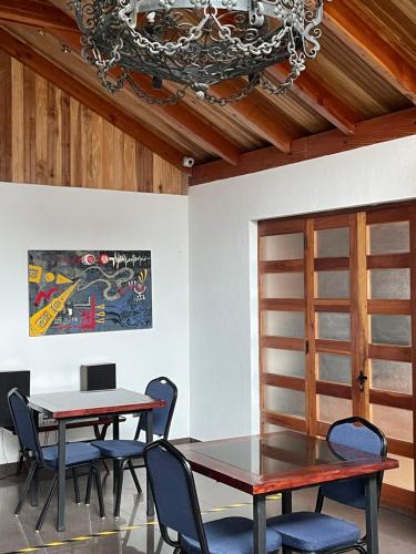 uma sala de jantar com duas mesas e cadeiras e um lustre em Residencial Astorga em Rancagua