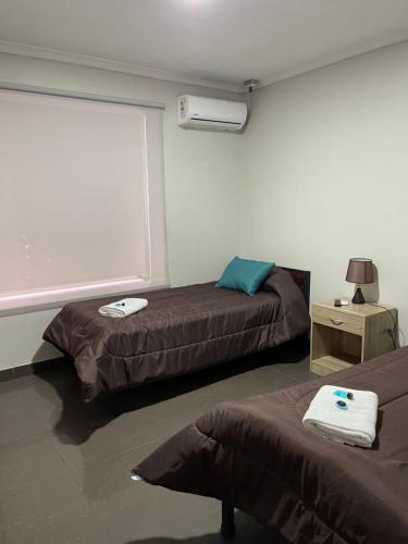 a room with two beds and a window at Residencial Astorga in Rancagua