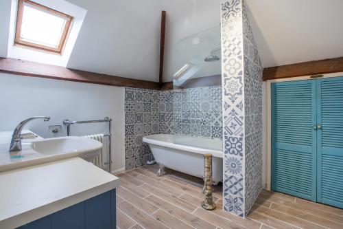 La salle de bains est pourvue d'une baignoire et d'un lavabo. dans l'établissement Teacher's Cottage, à Taunton
