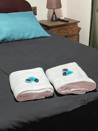 a pair of towels sitting on top of a bed at Residencial Astorga in Rancagua