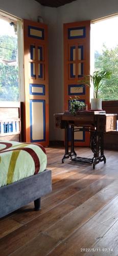a room with a piano and a bed and a desk at HOSTAL CASA VICTORIA PIJAO in Pijao