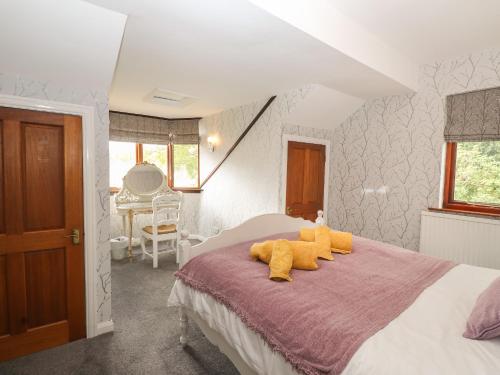 un dormitorio con una cama con animales de peluche amarillos. en Fir Trees, en Windermere