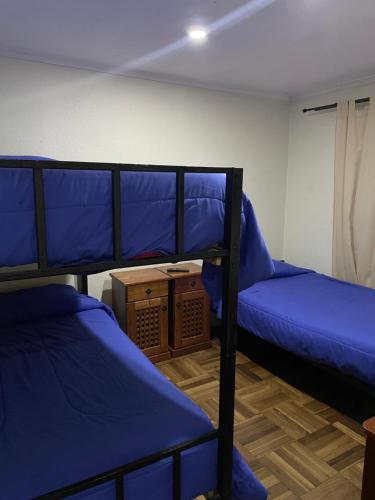 two bunk beds in a room with blue sheets at Manso de Velasco in Rancagua