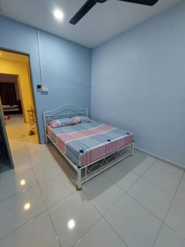 a bedroom with a bed in a blue room at Flora Homestay Jenjarom, Banting,Telok Panglima Garang in Jenjarum
