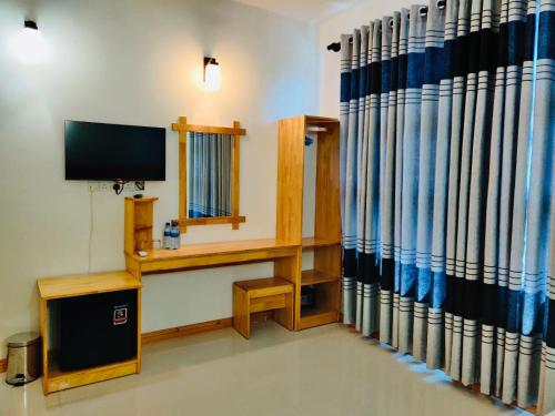 a room with a television and a desk with a tv at Stay Salty in Gaafaru