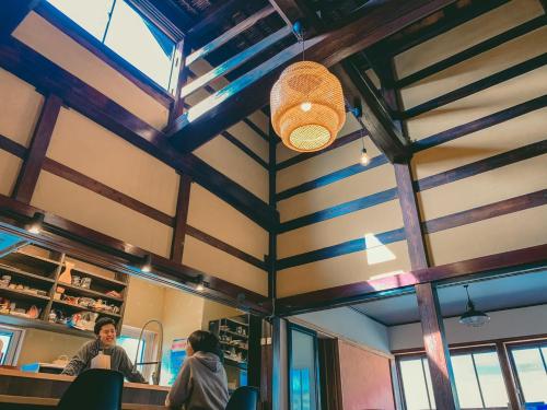 a group of people sitting at a table in a restaurant at 古民家ゲストハウス結舎-YUINOYA- in Nakanoto