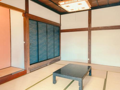 a room with a table in front of a window at 古民家ゲストハウス結舎-YUINOYA- in Nakanoto