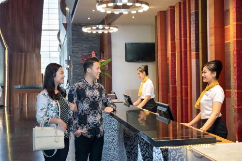 a group of people standing around a reception desk at Novotel Palembang in Palembang