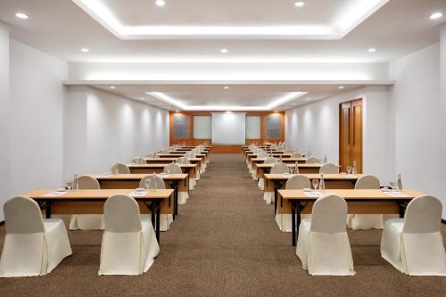 a large room with rows of tables and chairs at Novotel Palembang in Palembang