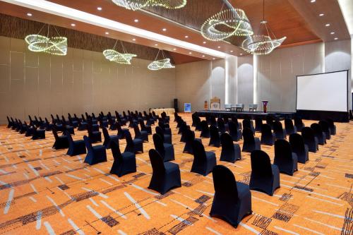 a lecture hall with chairs and a screen at Novotel Palembang in Palembang