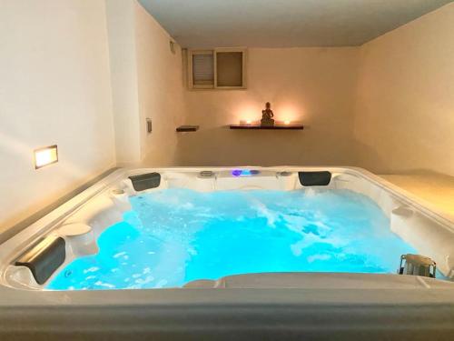 een jacuzzi in een kamer met blauw water bij Villa Rossa Gozo - 5 bedroom ensuite with pool & jacuzzi in Xewkija