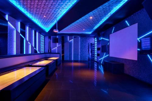 a room with a bar with blue lights at Novotel Palembang in Palembang