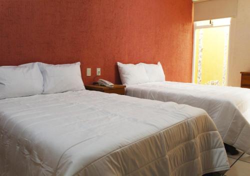 una camera d'albergo con due letti e un telefono di Hotel Malinalli Bella Vista a Puebla