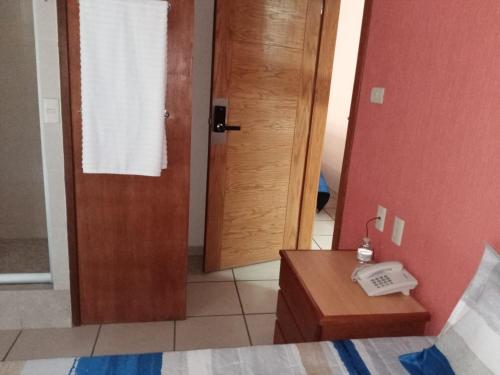 a bedroom with a door and a phone on a table at Hotel Malinalli Bella Vista in Puebla