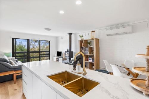 a kitchen with a sink and a living room at Bayview Number Four in Lorne