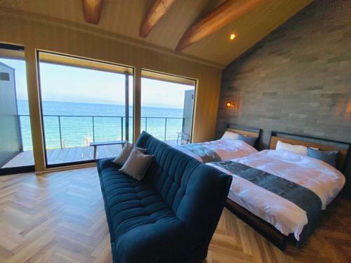 ein Schlafzimmer mit einem großen Bett und einem Sofa in der Unterkunft AWAJI OCEAN BASE in Tusi